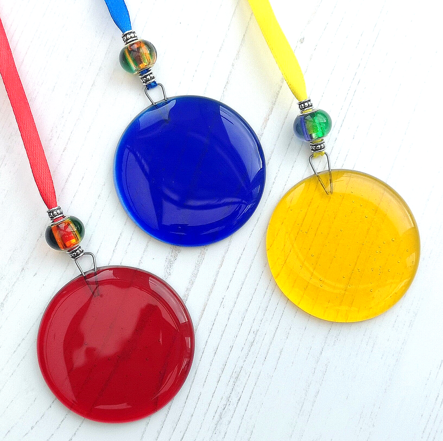Handmade fused glass round rainbow coloured hanging Christmas tree decoration. Glass suncatcher bauble ornament, holiday decor gift, festive present.