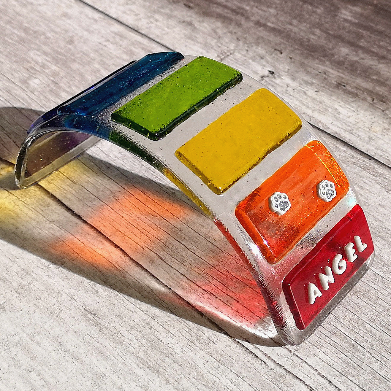 Handmade fused glass curved rainbow bridge. 3D pet paw prints. Free standing personalised 3D name rainbow arch. Brightly coloured glass gift. Suncatcher, light catcher. Gift for pet loss, remembrance.