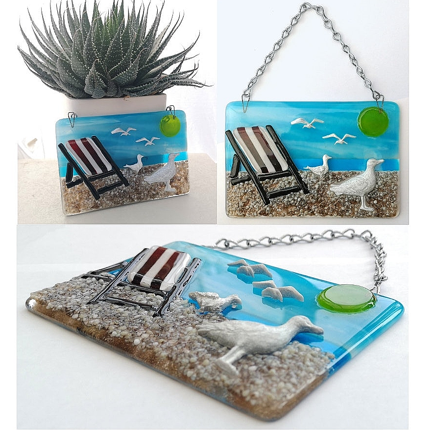 Handmade fused glass 3D Seagull and Deckchair Hanging Picture. Seaside suncatcher wall art, beach gift decoration, sea ocean scene with glass pebbles, sea birds, sun and blue sky.