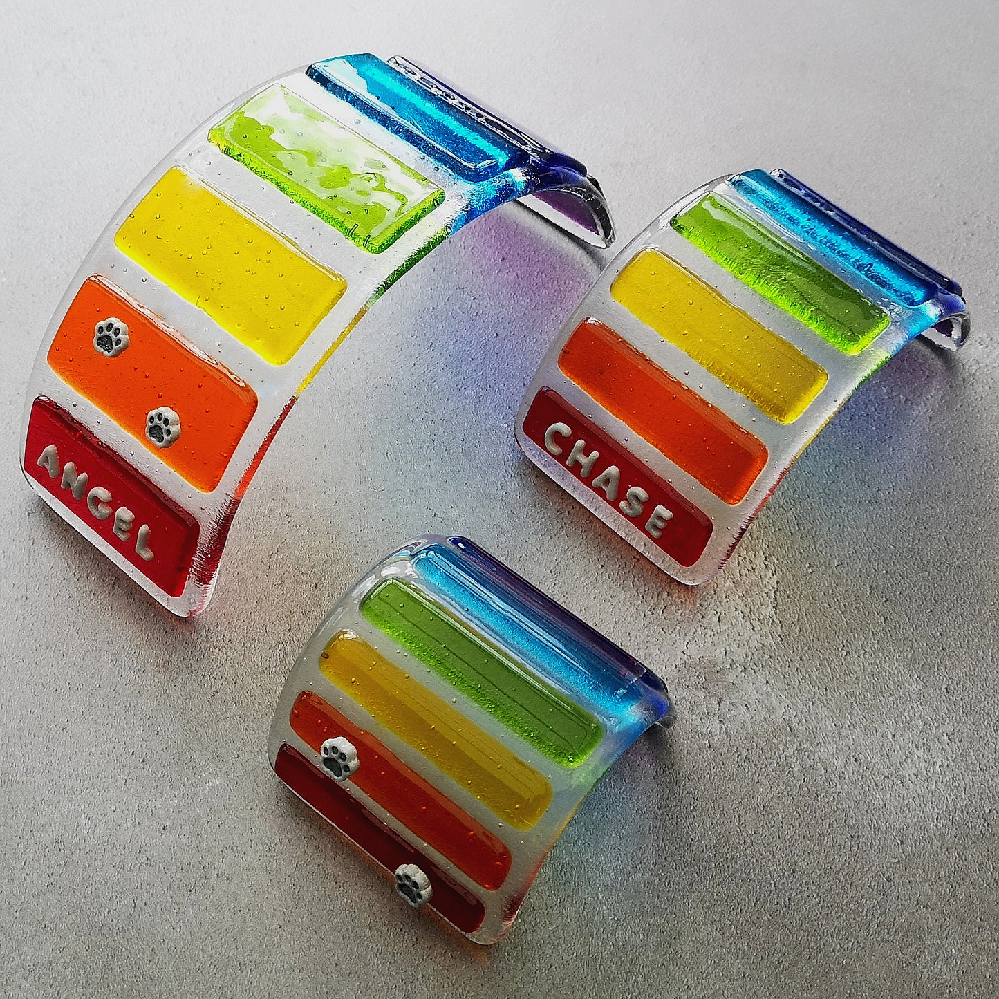 Handmade fused glass curved rainbow bridge. 3D pet paw prints. Free standing personalised 3D name rainbow arch. Brightly coloured glass gift. Suncatcher, light catcher. Gift for pet loss, remembrance.