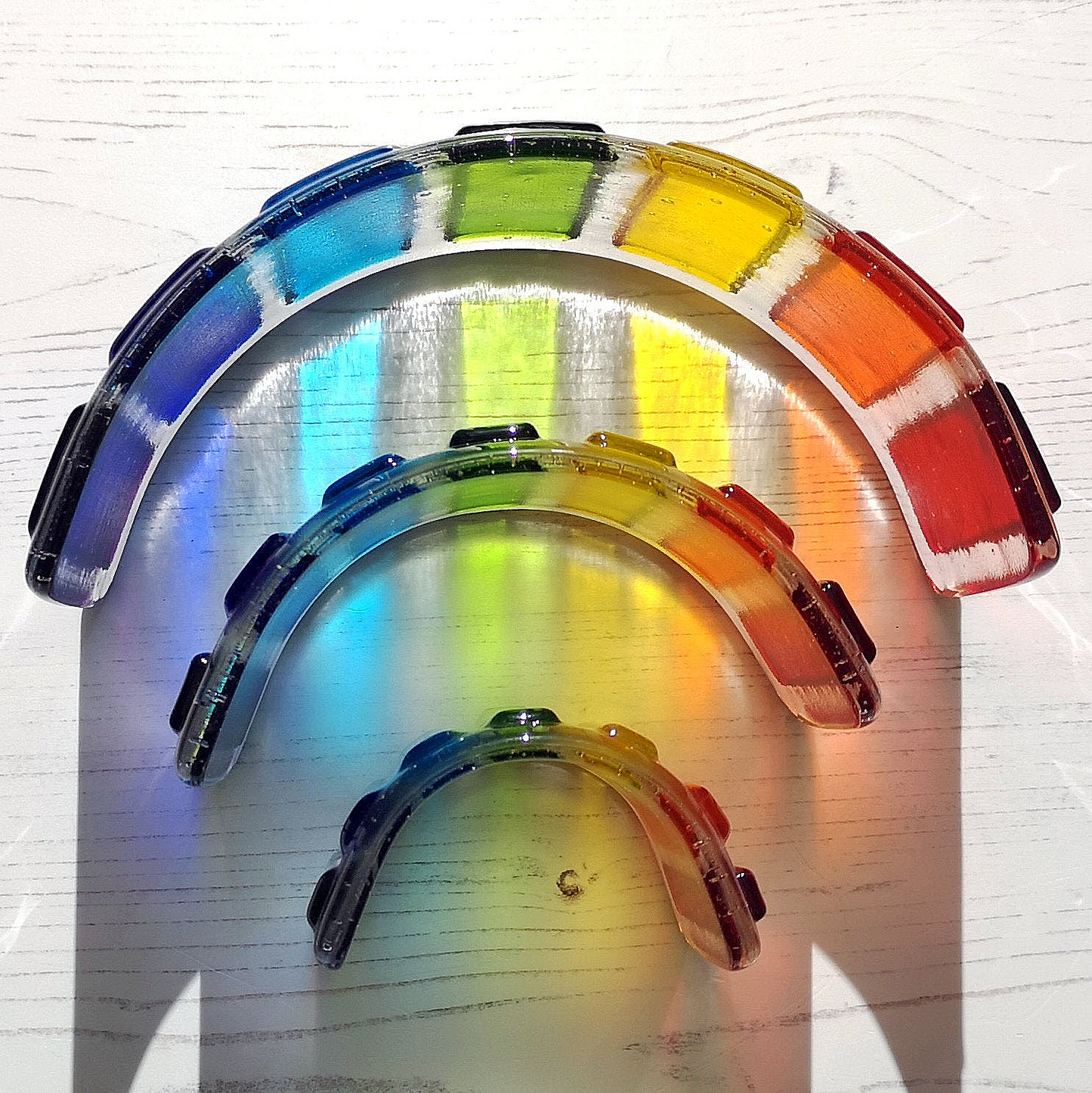 Handmade fused glass curved rainbow bridge. 3D pet paw prints. Free standing personalised 3D name rainbow arch. Brightly coloured glass gift. Suncatcher, light catcher. Gift for pet loss, remembrance.