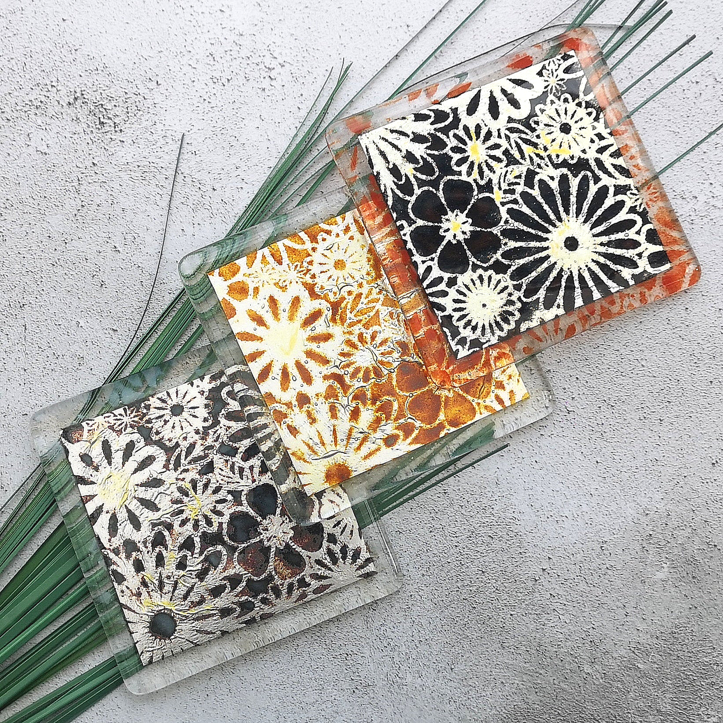 Handmade fused glass flowers on silver drinks coaster. Flower pattern design, glass tile art, hot drink table mat, floral nature gift. Embedded pure silver foil, wall tile home decoration, dining table protection.