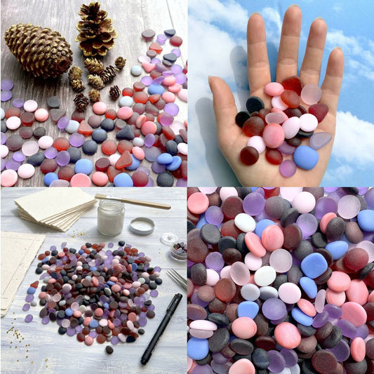 A four-panel collage showing round, flat decorative tumbled glass or pebbles in many colours. The top-left panel shows the stones scattered on a wood surface with pinecones nearby; the top-right panel shows a hand holding a handful of the sea glass against a blue sky background; the bottom-left panel shows the frosted glass arranged with small craft supplies on a white table; the bottom-right panel is a close-up of the multicoloured stones.
