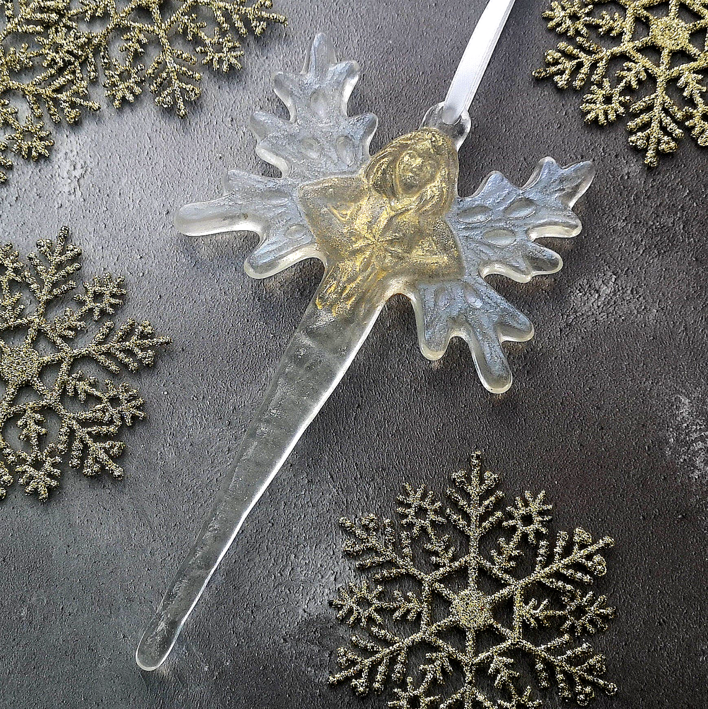 Festive display of the glass fairy / angel icicle ornament, hanging amongst traditional Christmas gold snowflake decor