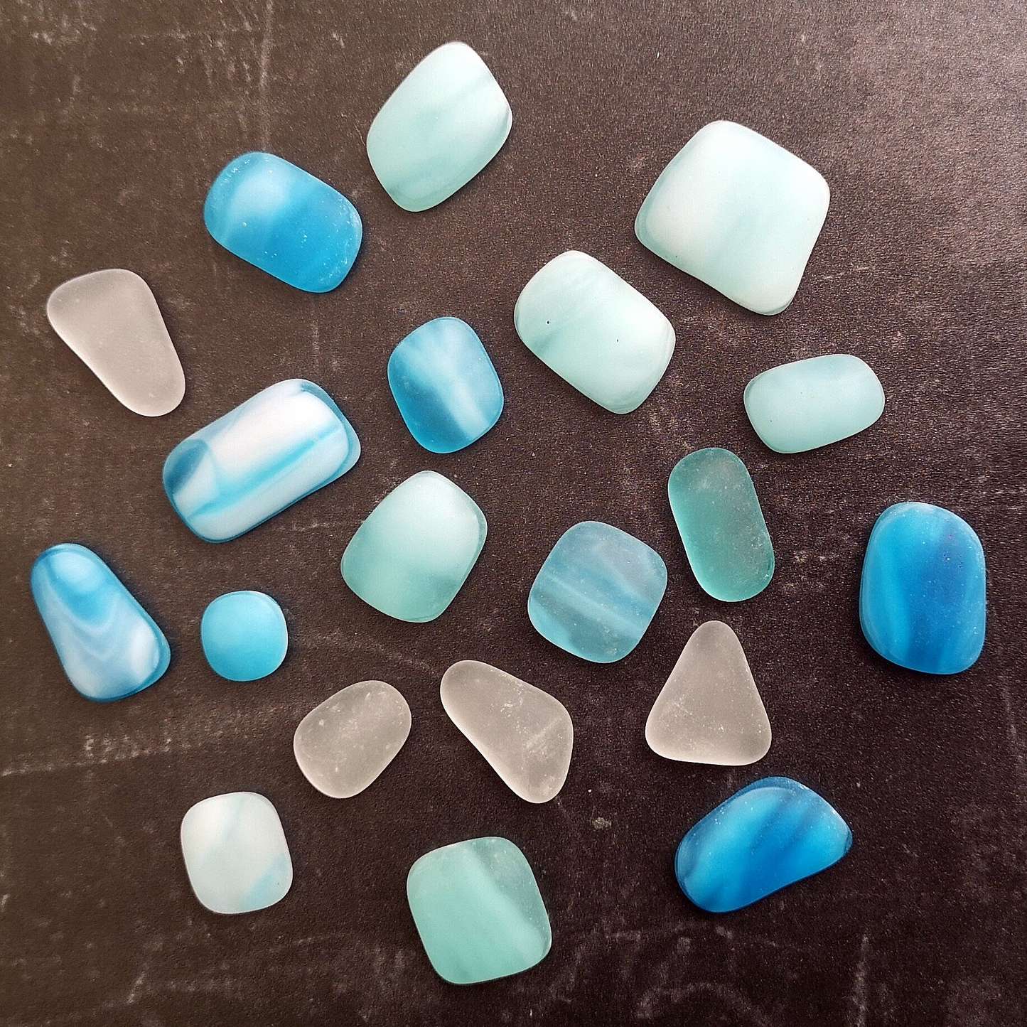 Elegant mix of tumbled glass in shades of light blue and turquoise, along with clear pieces, arranged to highlight their creative potential