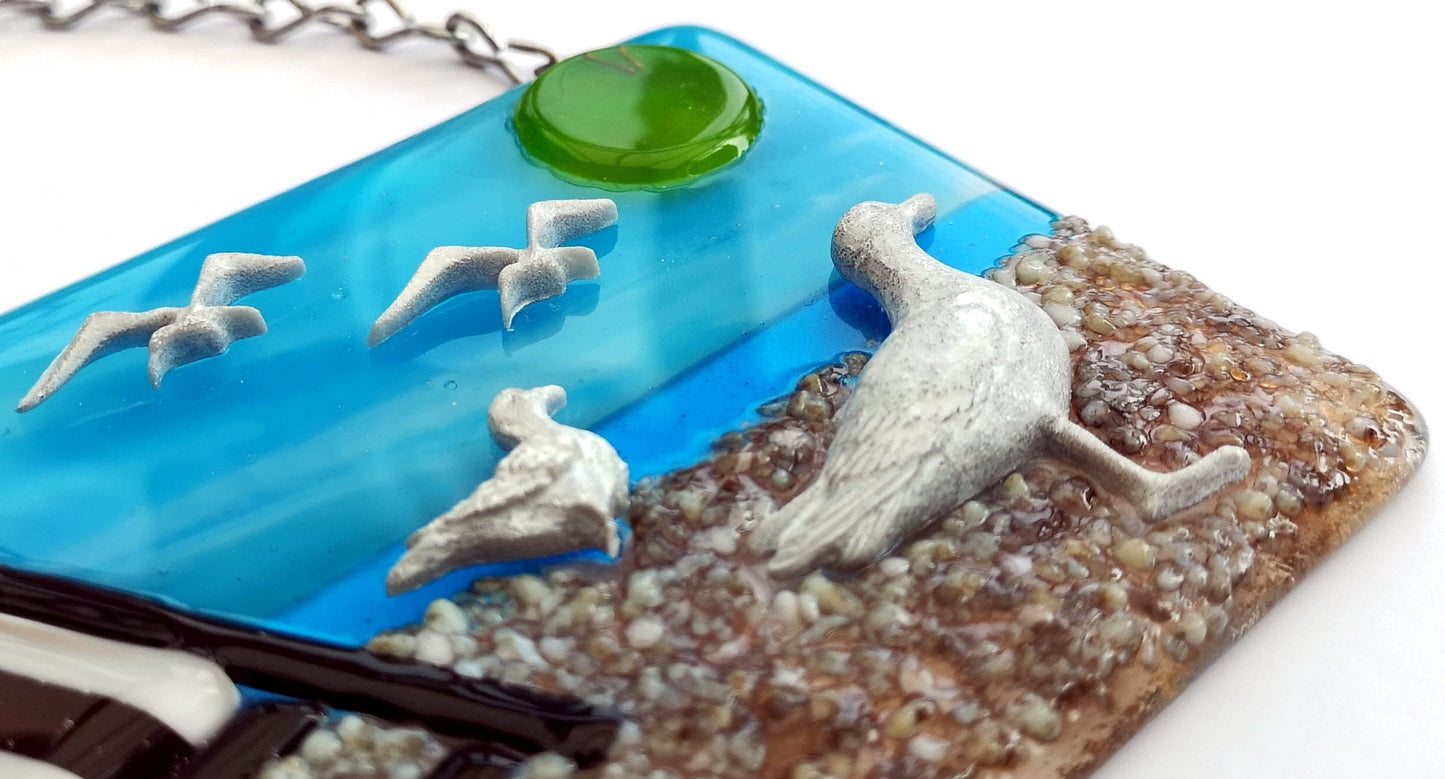Handmade fused glass 3D Seagull & Deckchair Hanging Picture. Seaside suncatcher wall art, beach gift decoration, sea ocean scene with glass pebbles, sea birds, sun and blue sky.