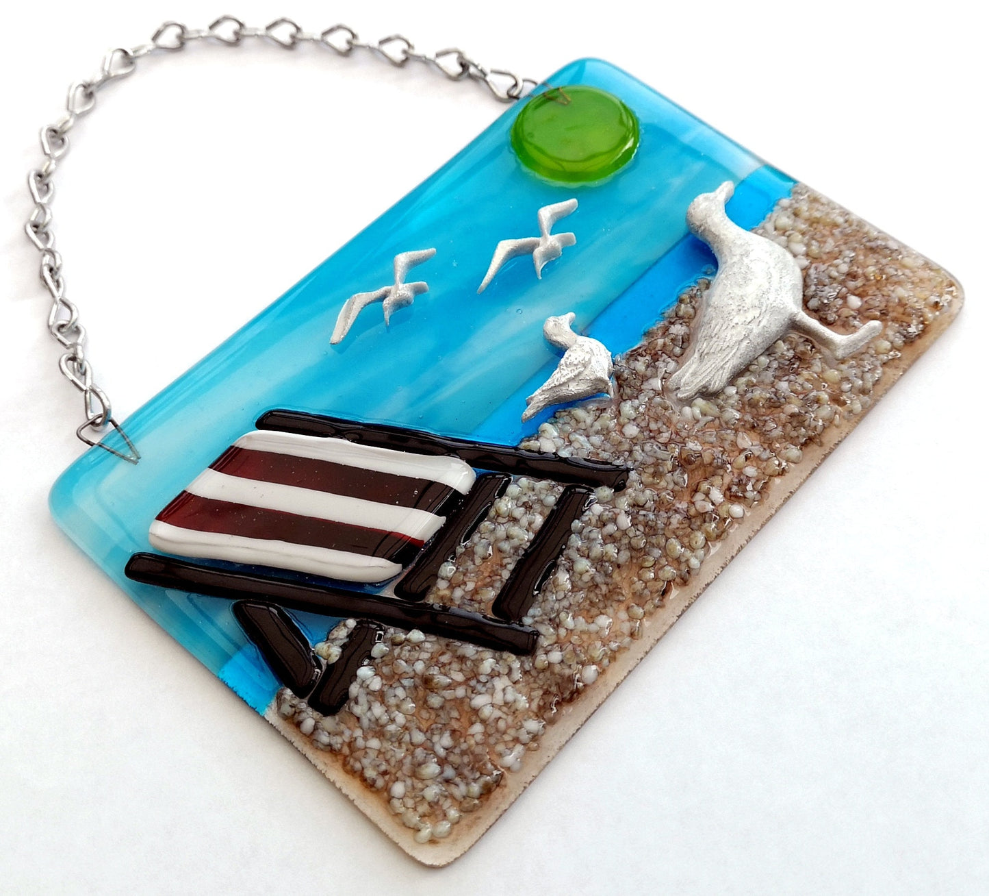 Handmade fused glass 3D Seagull & Deckchair Hanging Picture. Seaside suncatcher wall art, beach gift decoration, sea ocean scene with glass pebbles, sea birds, sun and blue sky.