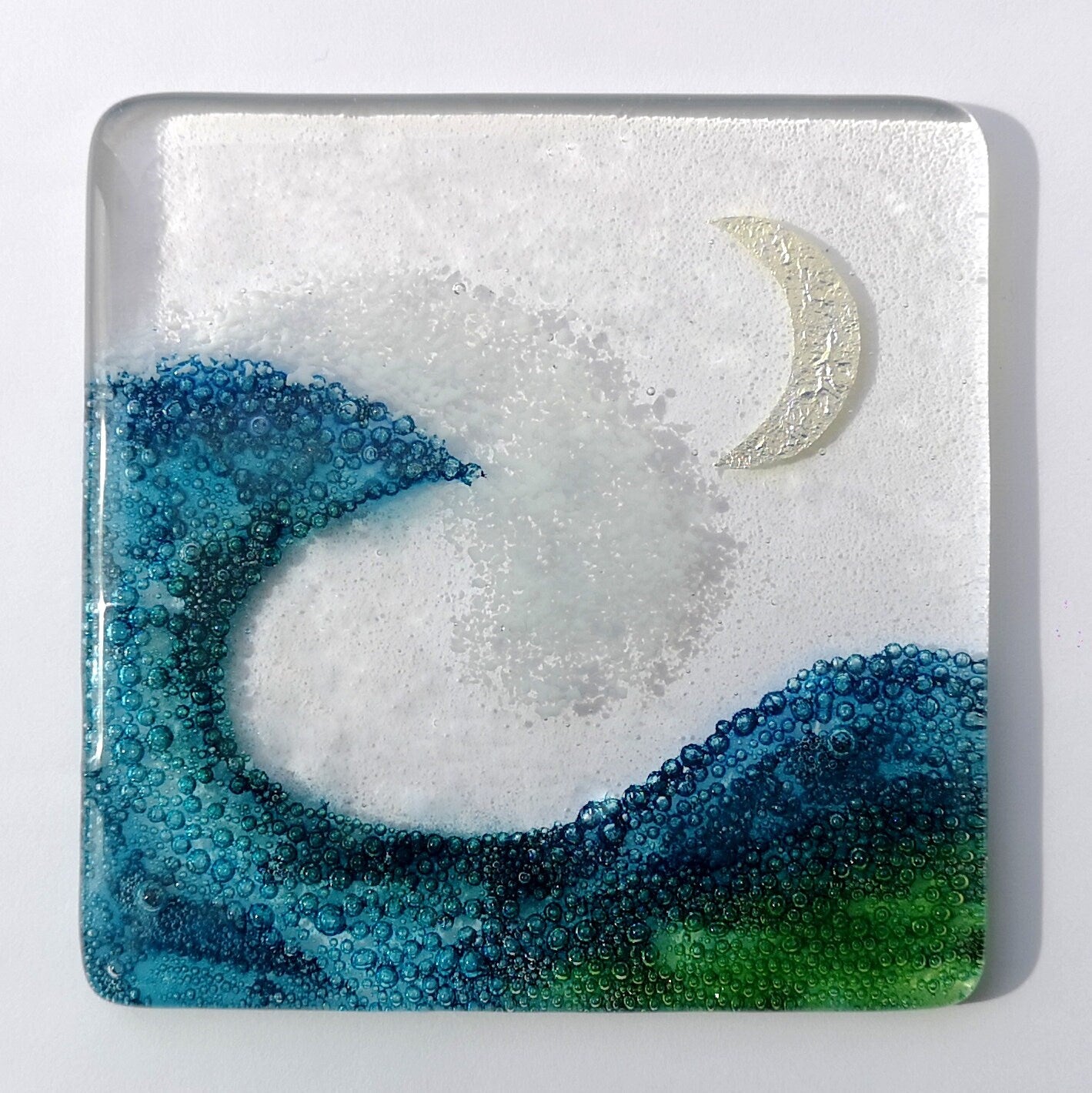 Handmade fused glass wave drinks coaster with embedded coloured bubbles and pure silver foil moon. Glass wall tile, hot drink table mat, sea, ocean home decoration, dining table protection. Beach gift.
