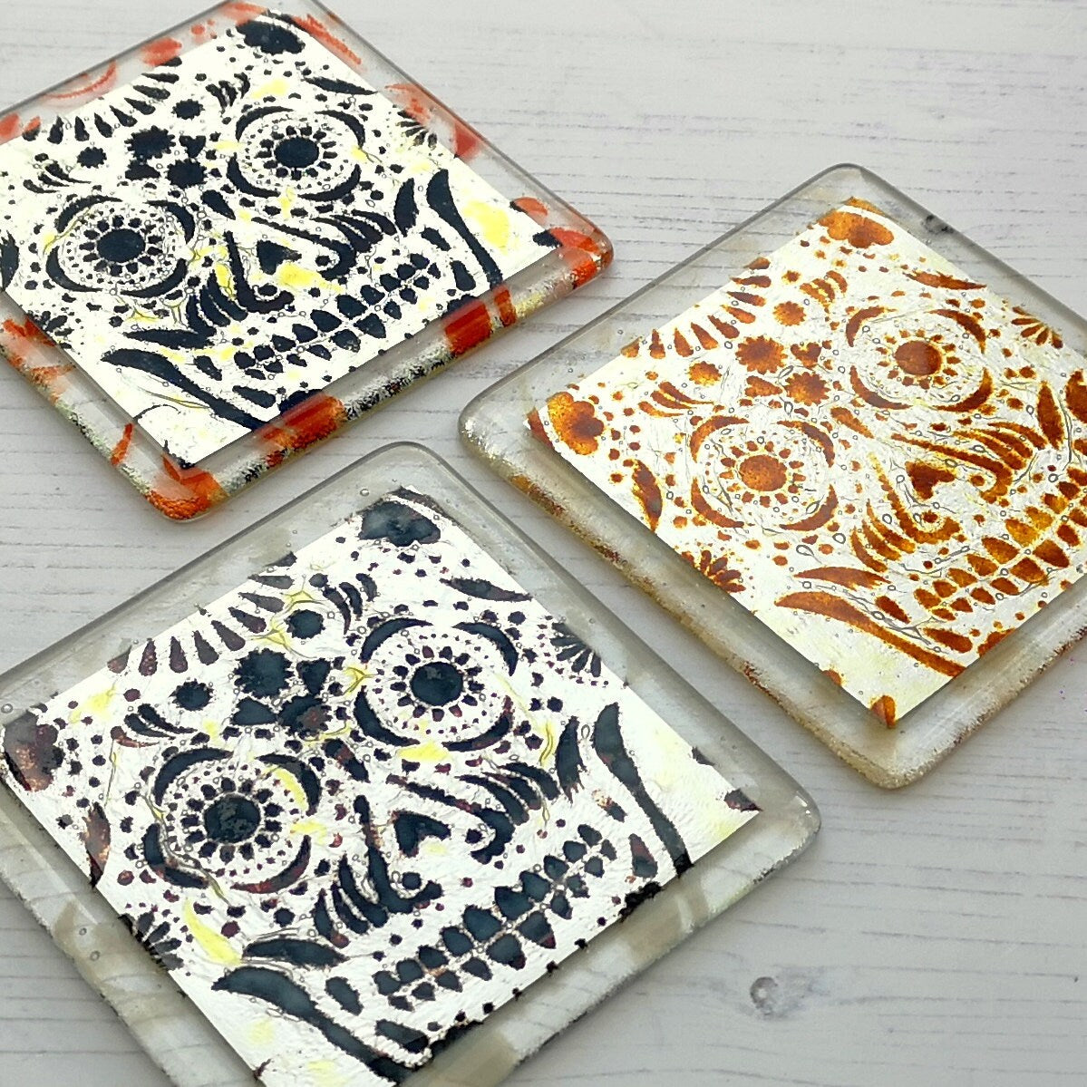 Handmade fused glass sugar skull on silver drinks coaster. Day of the dead pattern design, glass wall tile, hot drink table mat, Mexican skull gift. Embedded pure silver foil, home decoration, dining table protection. Dia de Los Muertos, La Calavera Catrina halloween spooky gift.