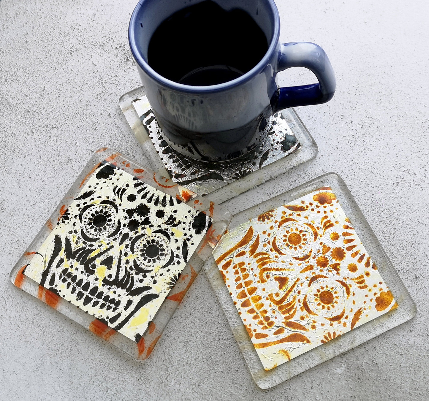 Handmade fused glass sugar skull on silver drinks coaster. Day of the dead pattern design, glass wall tile, hot drink table mat, Mexican skull gift. Embedded pure silver foil, home decoration, dining table protection. Dia de Los Muertos, La Calavera Catrina halloween spooky gift.