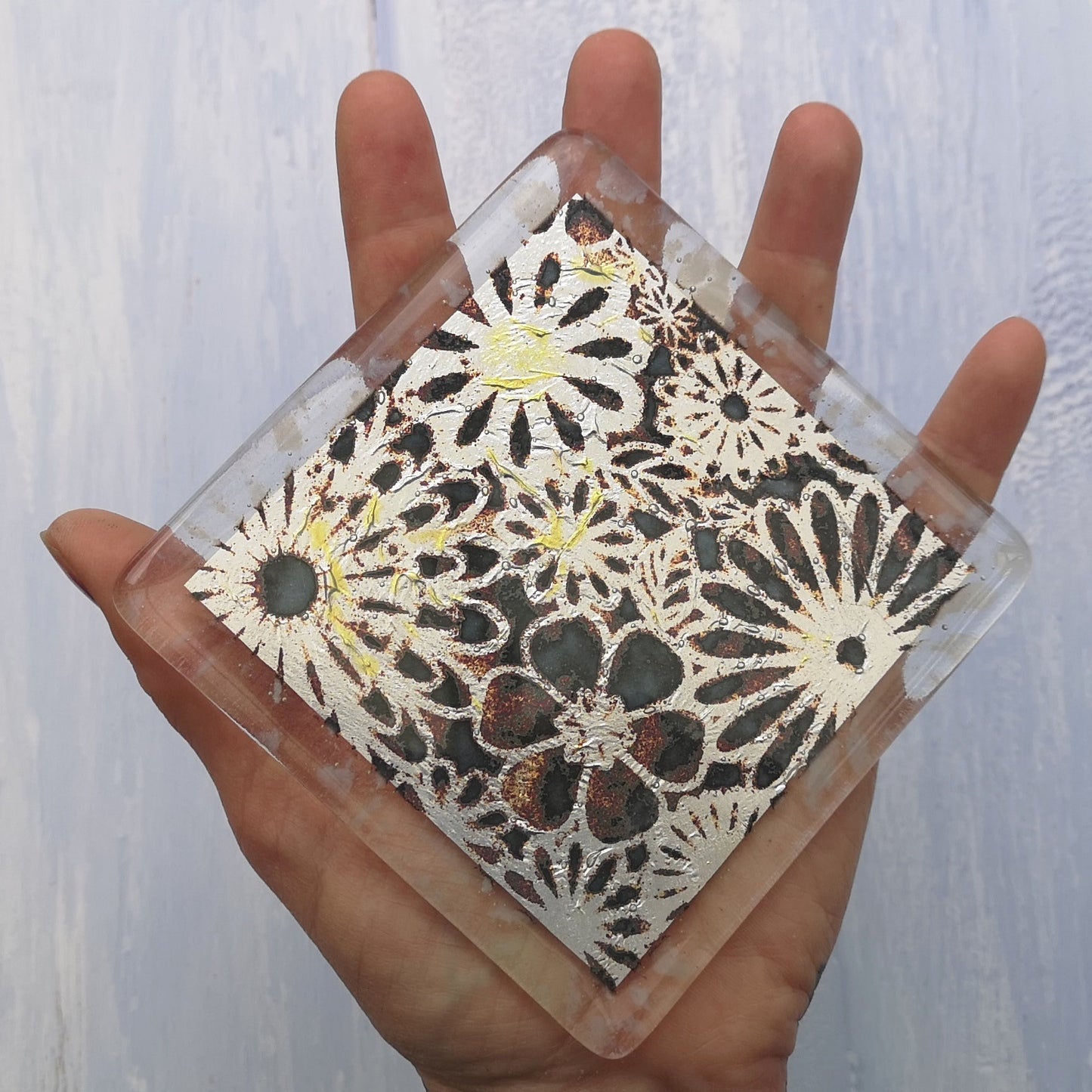 Handmade fused glass flowers on silver drinks coaster. Flower pattern design, glass tile art, hot drink table mat, floral nature gift. Embedded pure silver foil, wall tile home decoration, dining table protection.
