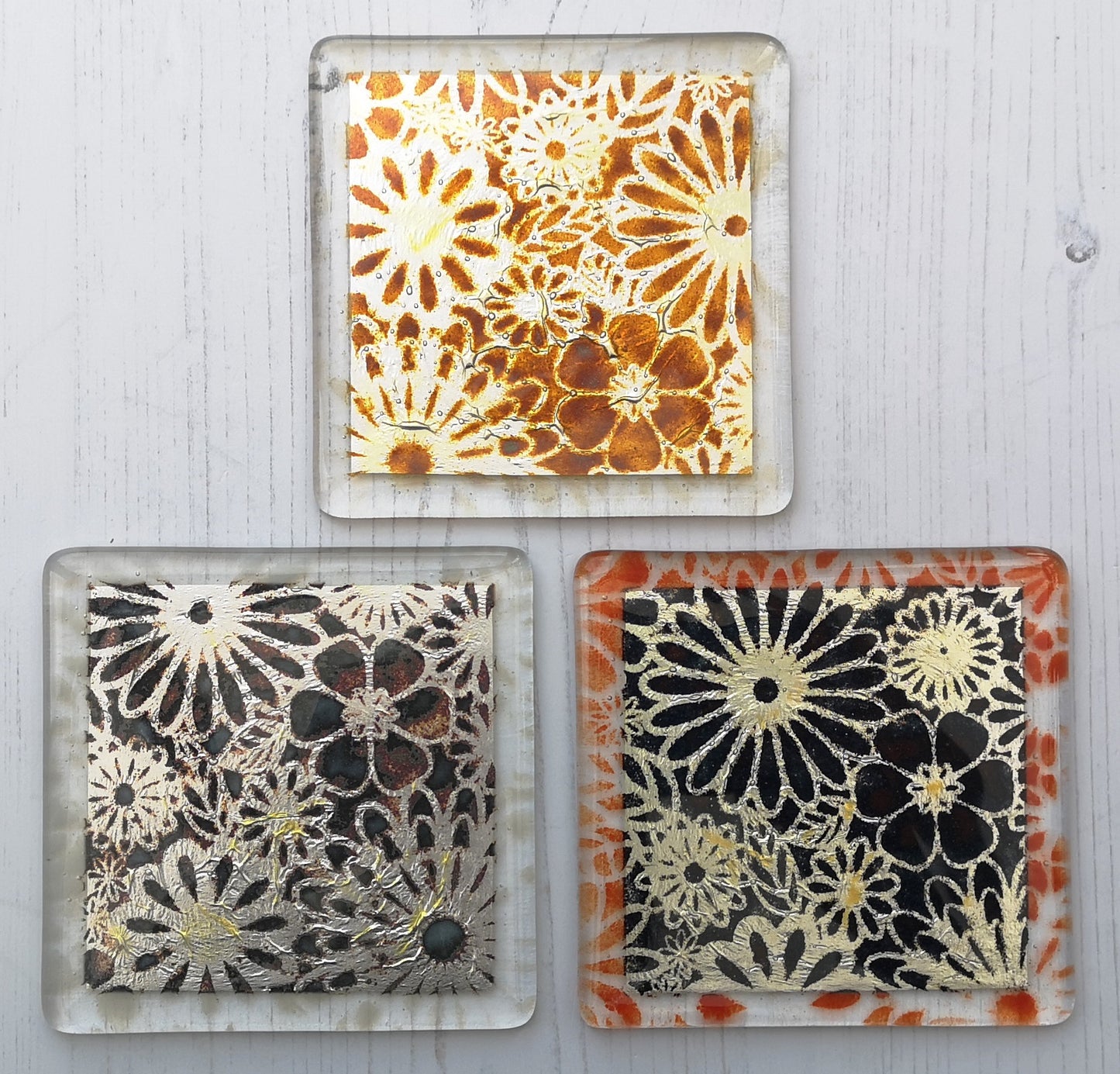 Handmade fused glass flowers on silver drinks coaster. Flower pattern design, glass tile art, hot drink table mat, floral nature gift. Embedded pure silver foil, wall tile home decoration, dining table protection.