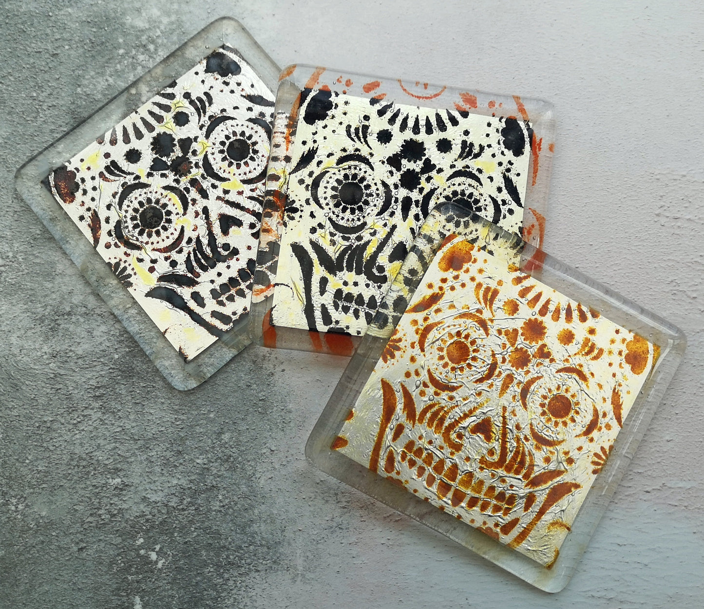 Handmade fused glass sugar skull on silver drinks coaster. Day of the dead pattern design, glass wall tile, hot drink table mat, Mexican skull gift. Embedded pure silver foil, home decoration, dining table protection. Dia de Los Muertos, La Calavera Catrina halloween spooky gift.