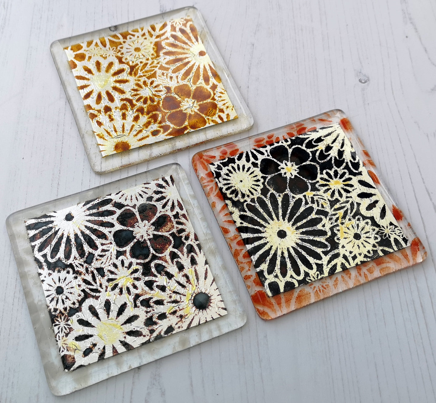 Handmade fused glass flowers on silver drinks coaster. Flower pattern design, glass tile art, hot drink table mat, floral nature gift. Embedded pure silver foil, wall tile home decoration, dining table protection.