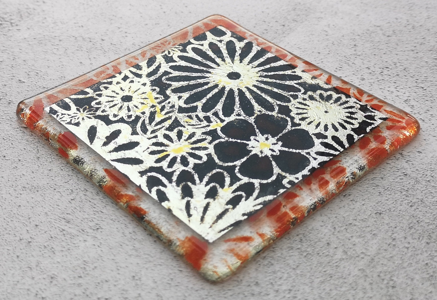 Handmade fused glass flowers on silver drinks coaster. Flower pattern design, glass tile art, hot drink table mat, floral nature gift. Embedded pure silver foil, wall tile home decoration, dining table protection.