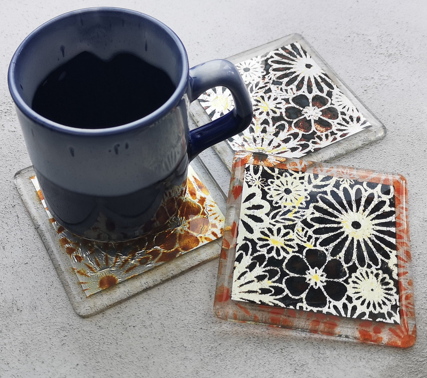 Handmade fused glass flowers on silver drinks coaster. Flower pattern design, glass tile art, hot drink table mat, floral nature gift. Embedded pure silver foil, wall tile home decoration, dining table protection.