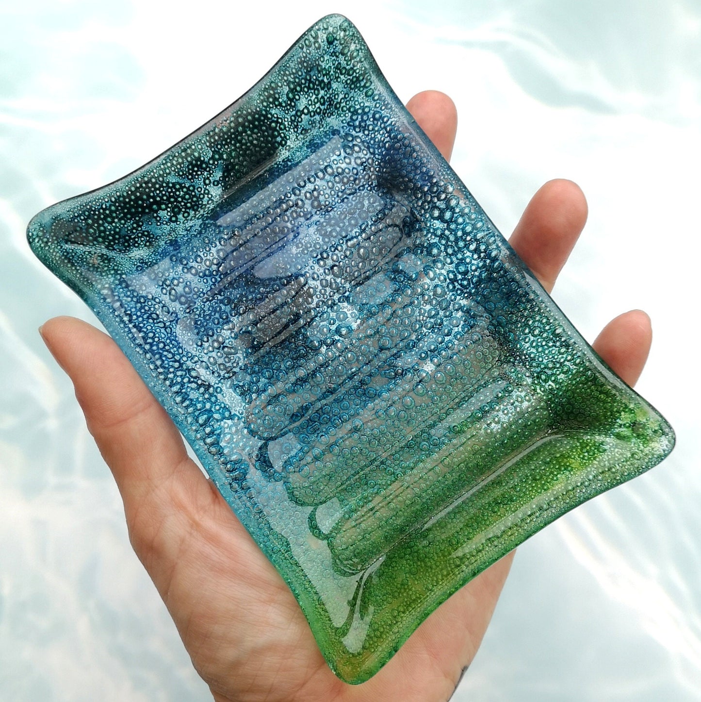 Handmade fused glass soap dish with bubbles encased inside the glass. Turquoise blue to green embedded coloured bubbles. Colourful bubbly glass soap holder. Brightly Coloured Gift.