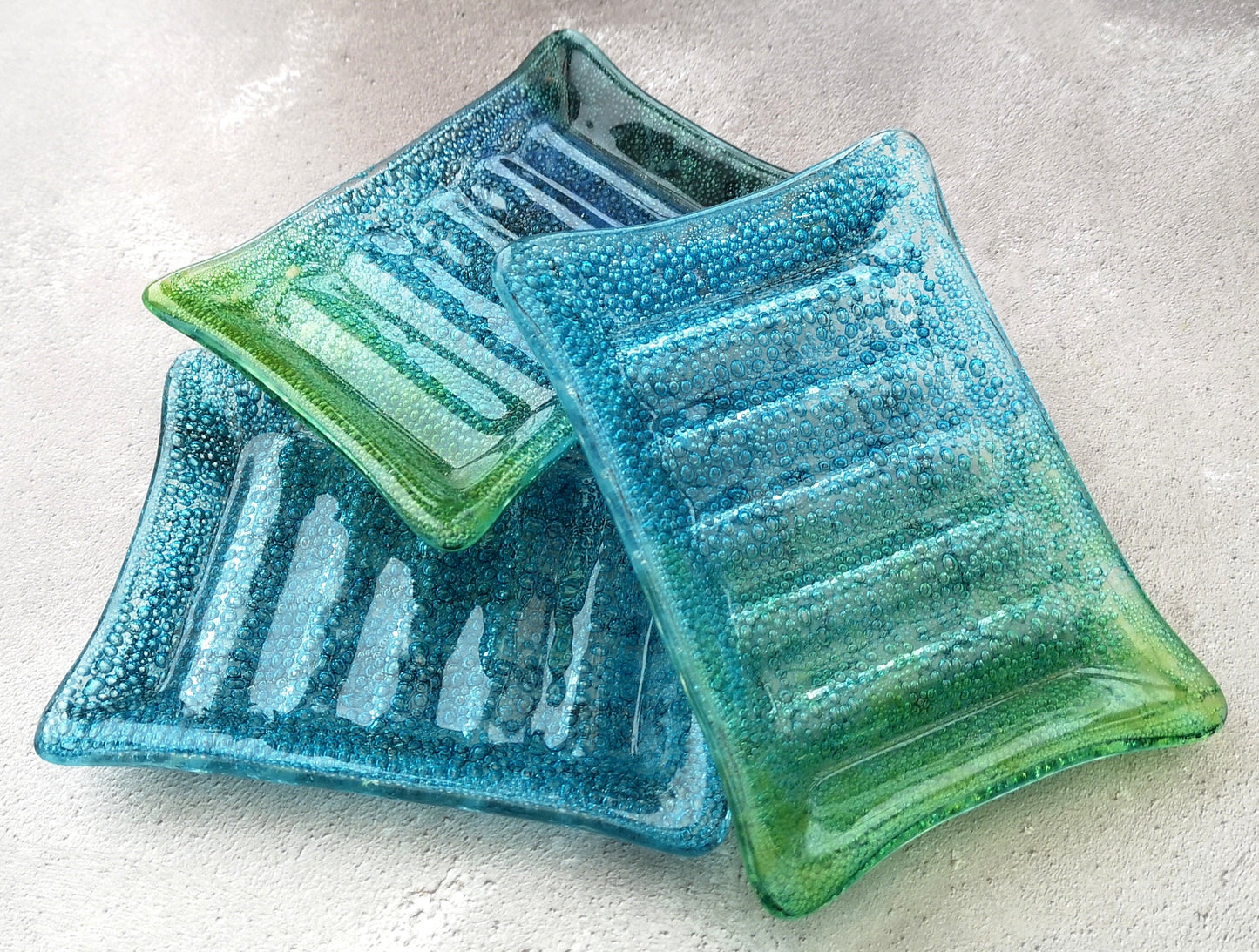 Handmade fused glass soap dish with bubbles encased inside the glass. Turquoise blue to green embedded coloured bubbles. Colourful bubbly glass soap holder. Brightly Coloured Gift.