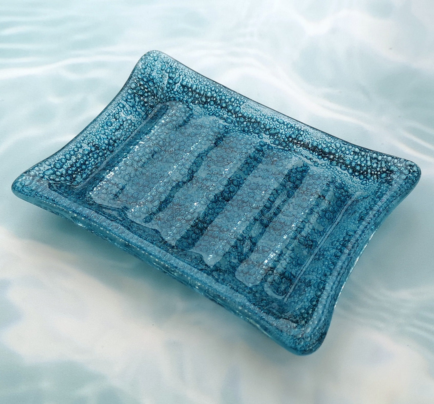 Handmade fused glass soap dish with bubbles encased inside the glass. Turquoise blue to green embedded coloured bubbles. Colourful bubbly glass soap holder. Brightly Coloured Gift.