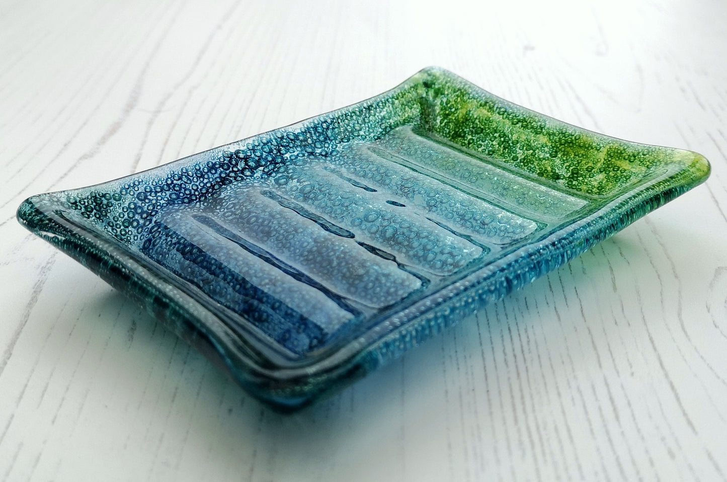 Handmade fused glass soap dish with bubbles encased inside the glass. Turquoise blue to green embedded coloured bubbles. Colourful bubbly glass soap holder. Brightly Coloured Gift.