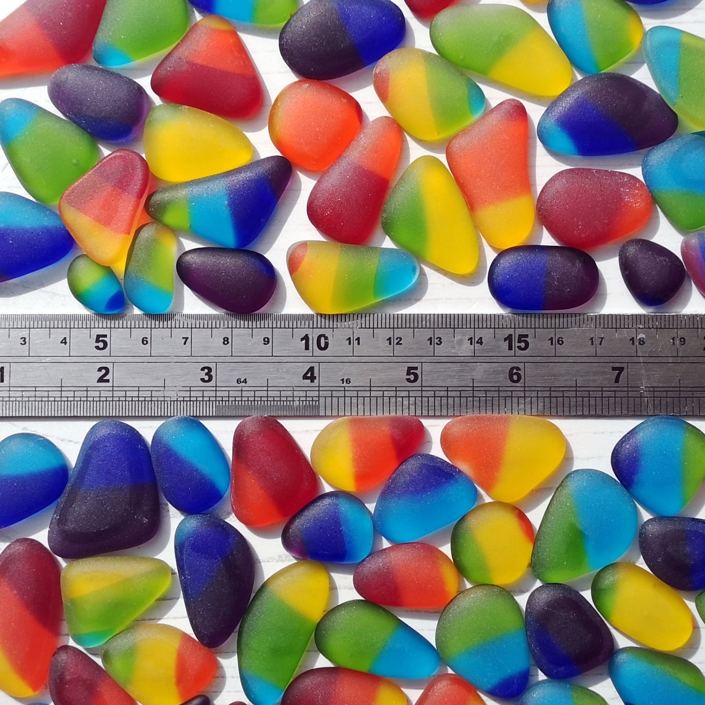 Richly colored tumbled glass assortment on a white backdrop, focusing on the raw, frosted texture ideal for eclectic art and design projects