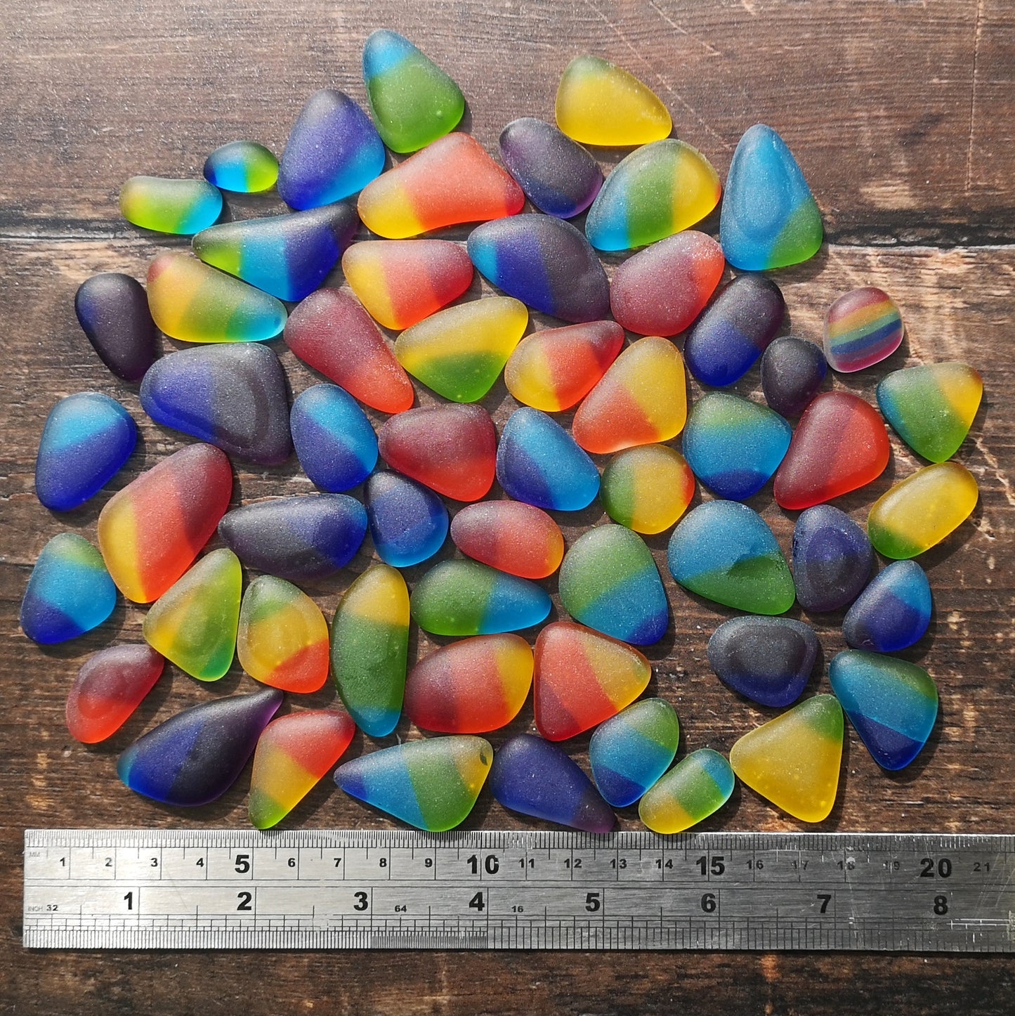 Multicolored tumbled glass, alongside a ruler to show size, for use in home decor and crafts