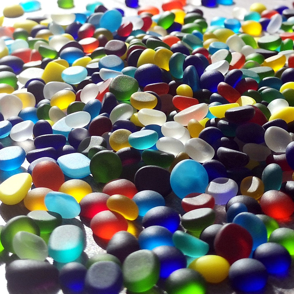 Pile of mixed-colour tiny tumbled glass pieces, showcasing a frosted sea glass appearance, ideal for adding a unique touch to DIY crafts