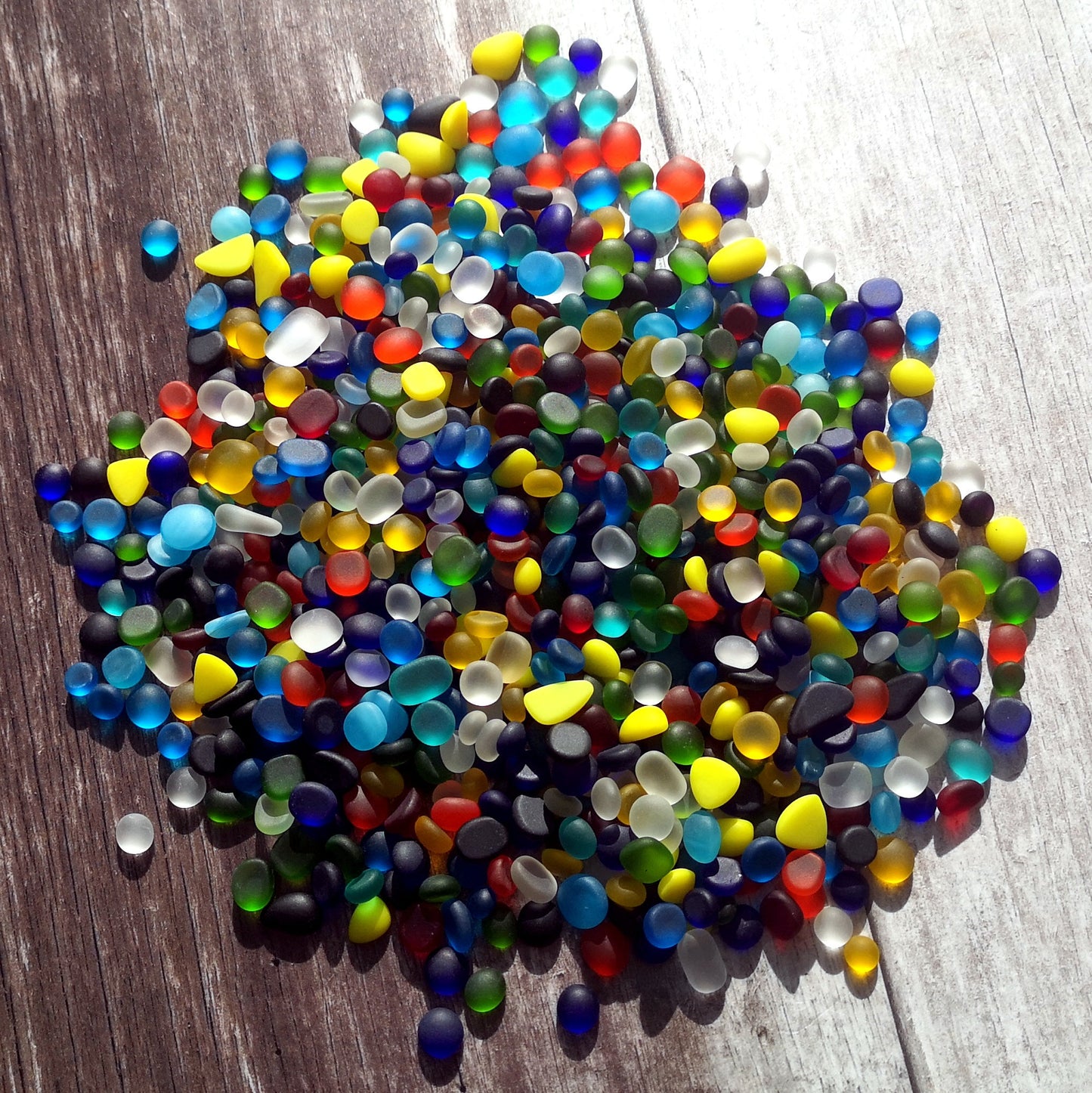 Eco-friendly tiny tumbled glass assortment in various colours, highlighting their sustainable and artistic appeal