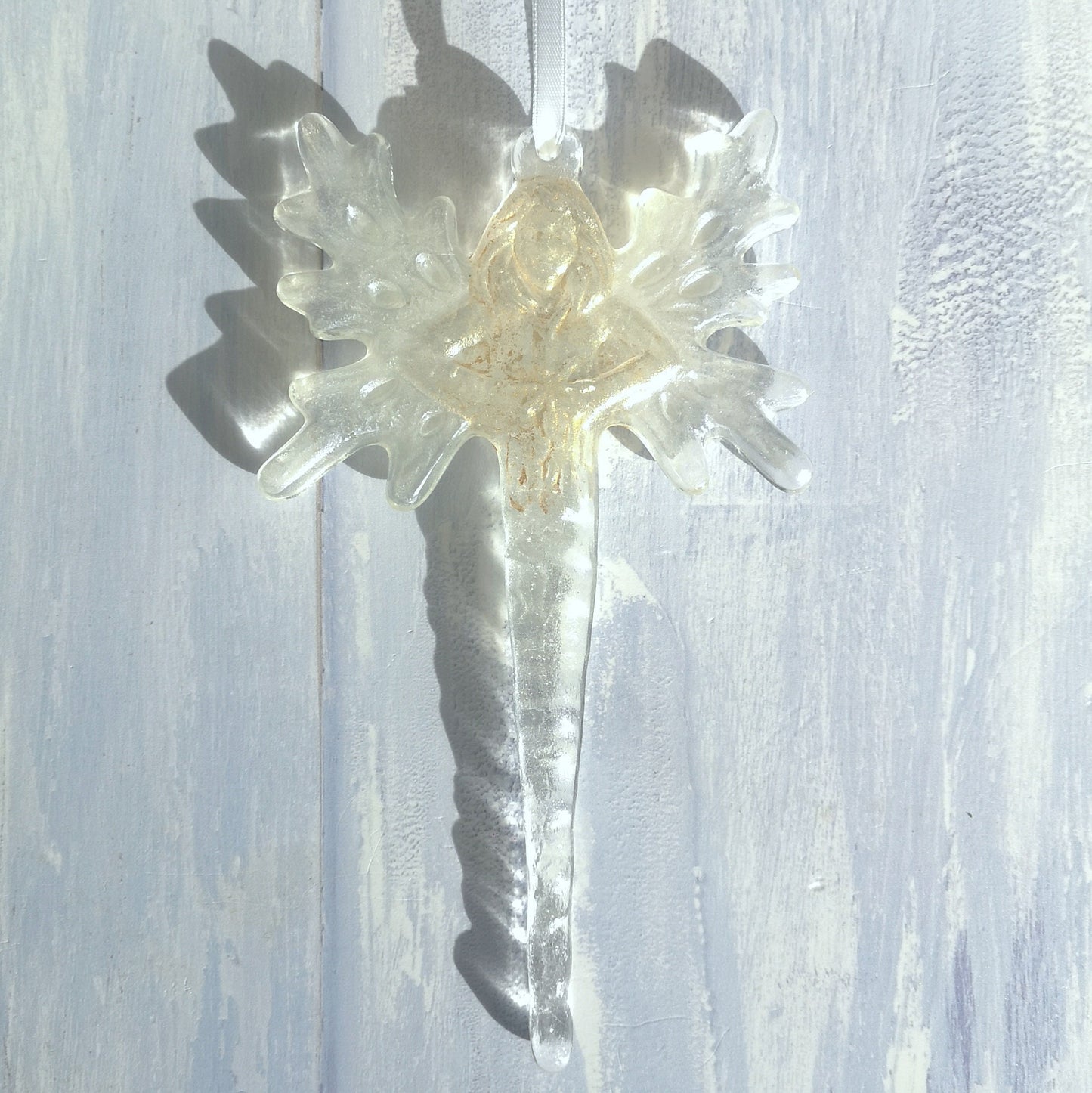 Handmade glass angel or fairy icicle, presented against a pale backdrop, showing its wintry ice appearance