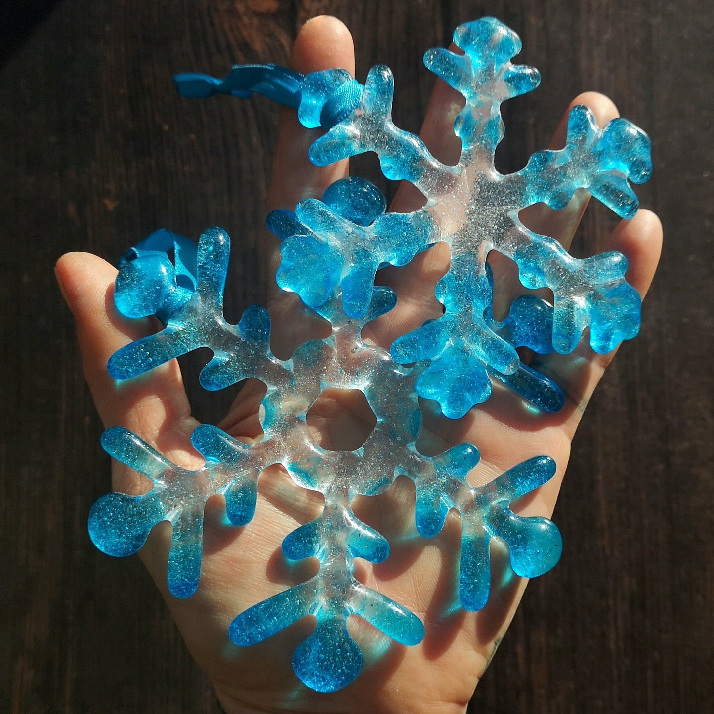 Turquoise Blue Tipped Snowflakes on a hand to show size - Captures the essence of winter with a hint of aqua and turquoise blue hues