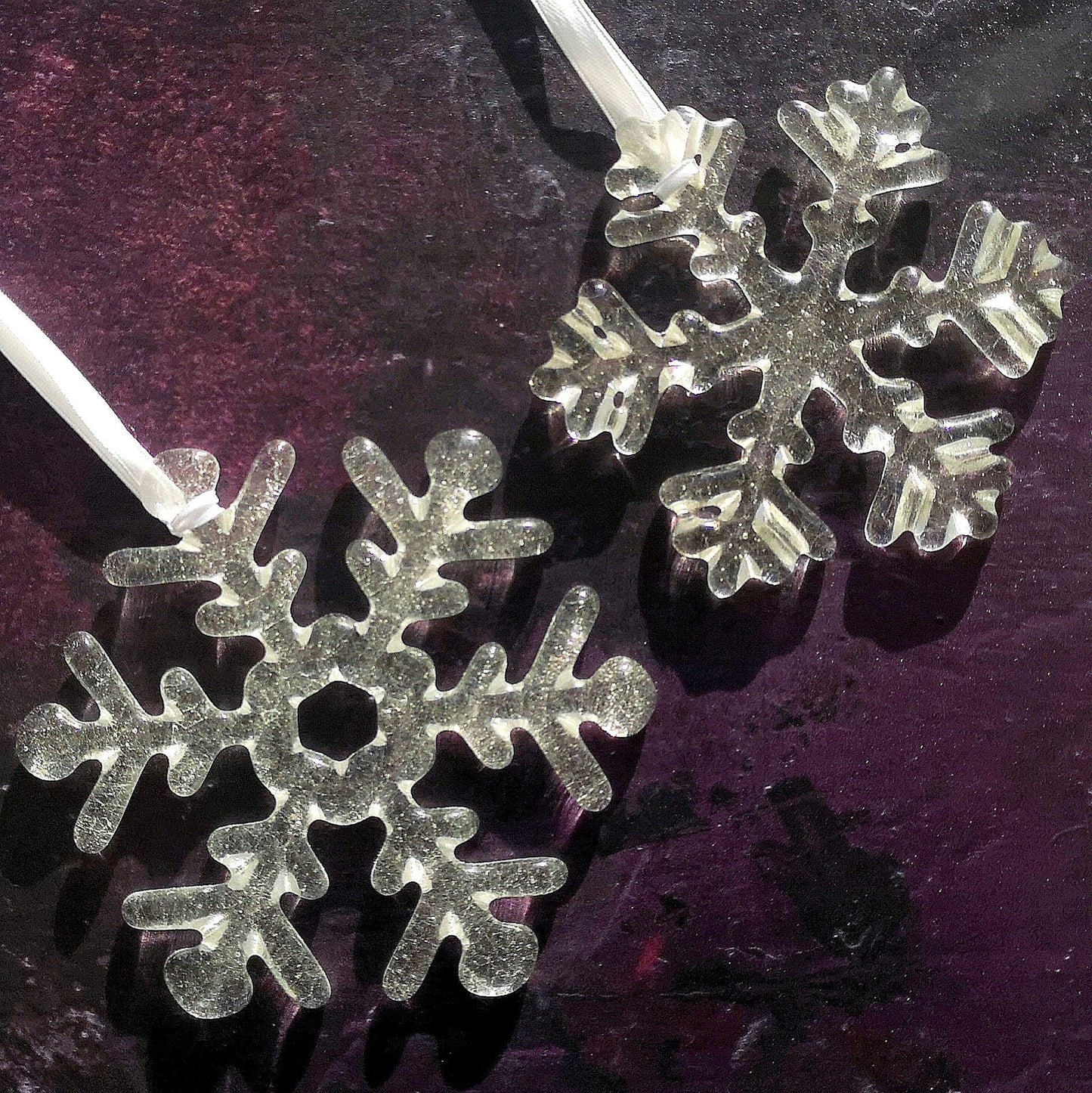 Elegant Snowflake Decorations in Clear, showcasing its frosty charm against a purple backdrop