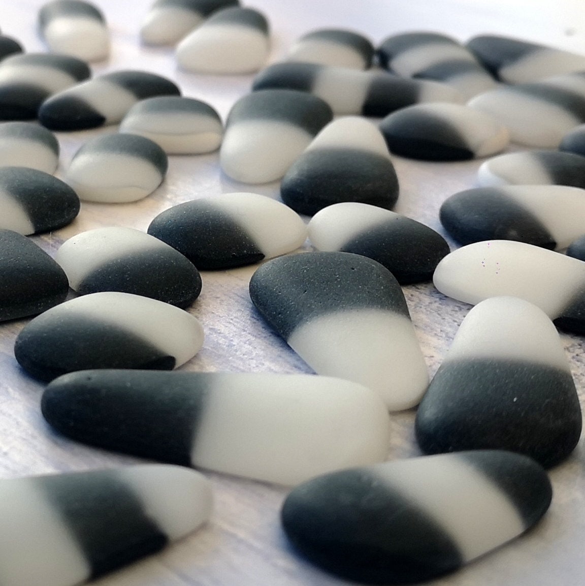 Close up view of black and white 2-tone tumbled seaglass ready for your creations
