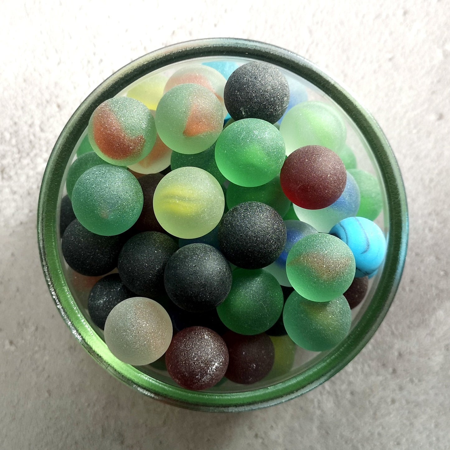 Pile of mixed colour tumbled glass marbles, showcasing a frosted sea glass appearance, ideal for adding a unique touch to DIY crafts