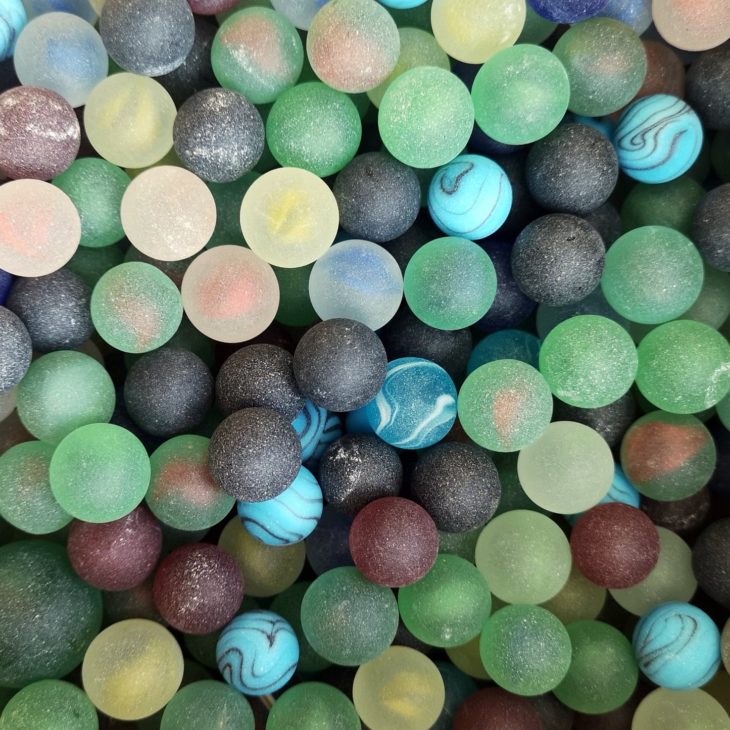 Pile of mixed colour tumbled glass marbles, showcasing a frosted sea glass appearance, ideal for adding a unique touch to DIY crafts