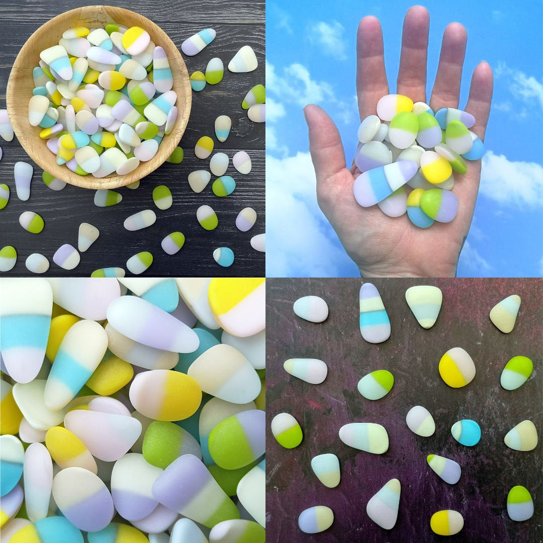 Collection of opaque pastel multicoloured tumbled glass pieces, arranged in a visually appealing pattern, emphasizing their diverse sizes and creative potential