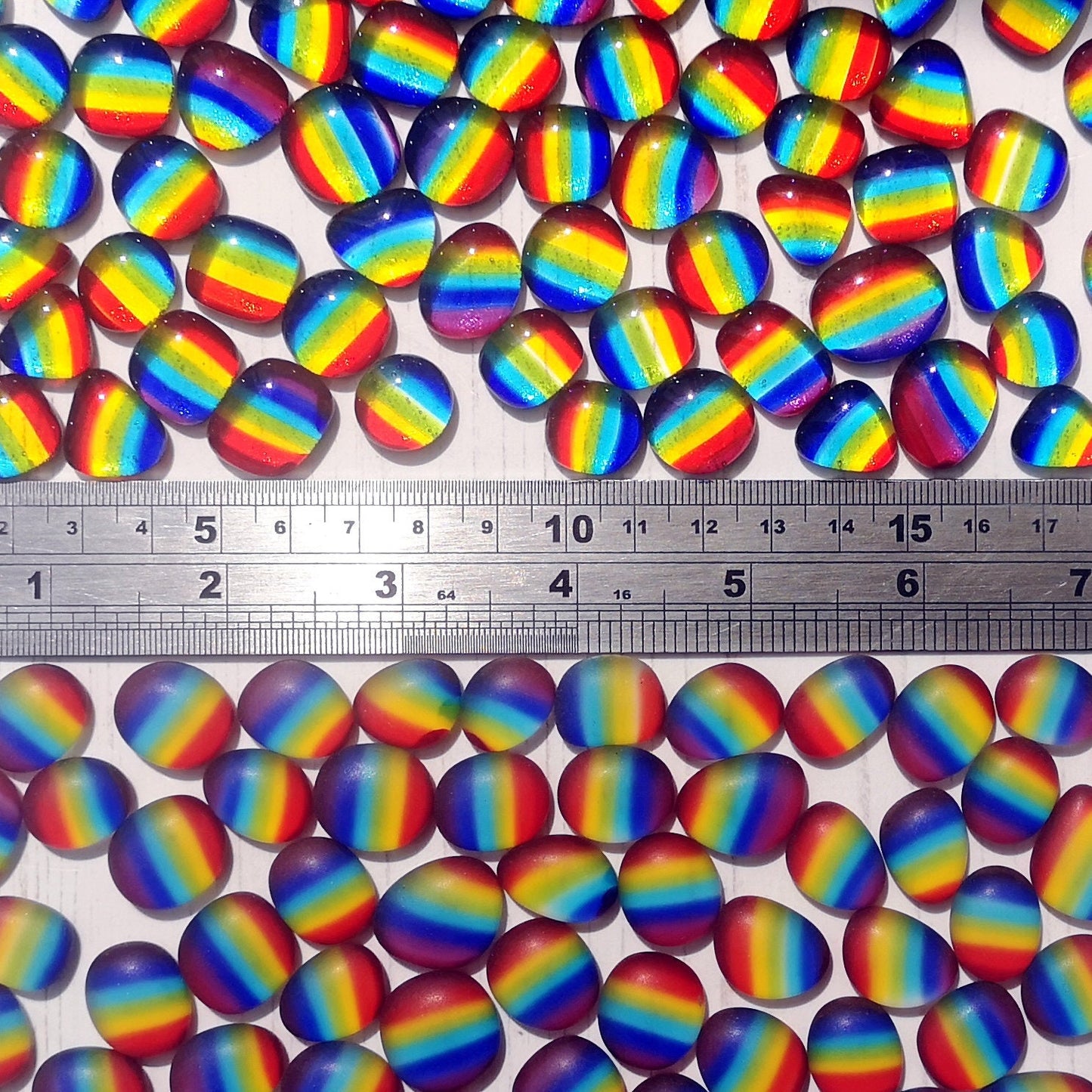 Multicoloured tumbled or polished finish glass, alongside a ruler to show size, for use in home decor and crafts