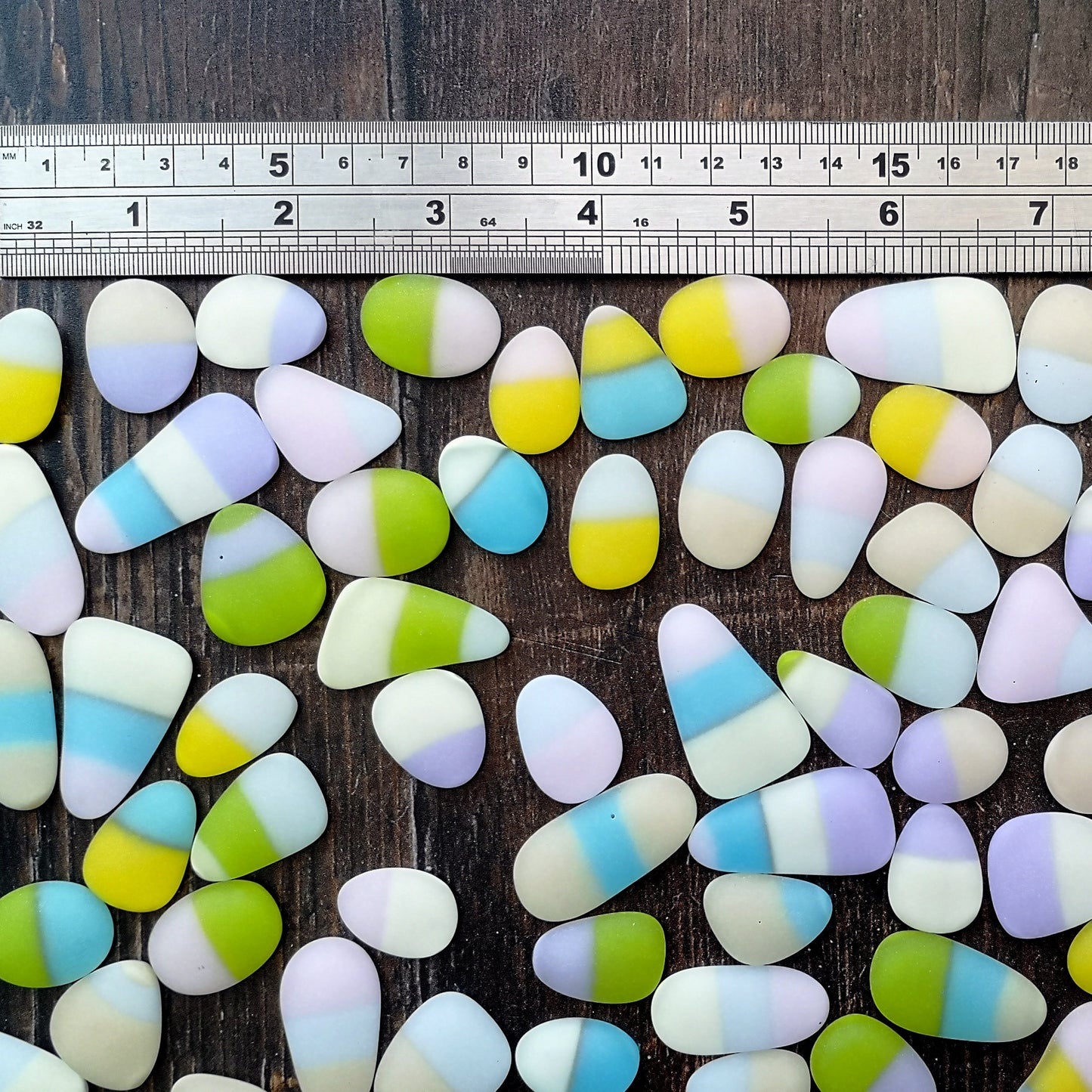Multicolored tumbled glass, alongside a ruler to show size, for use in home decor and crafts