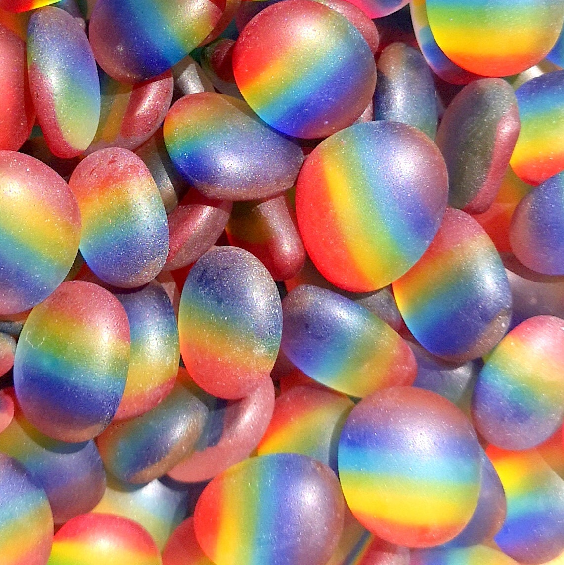 Pile of weathered, frosted sea glass-like tumbled pieces in a multitude of rainbow colours
