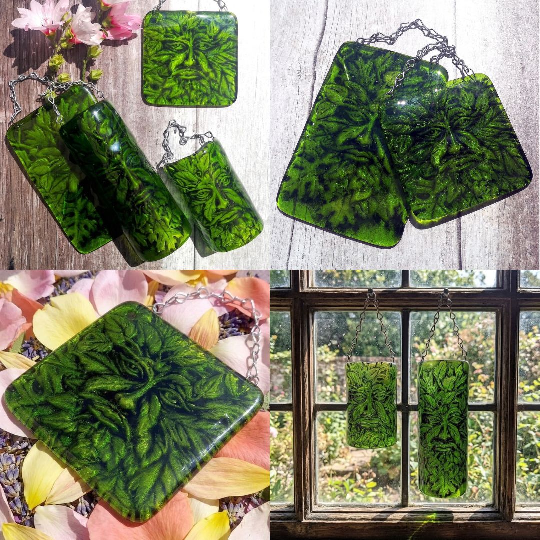A collage showing multiple images of  handmade fused green glass hanging wall plaques with a Greenman face and leaves embedded design, displayed on a wood surface, among pink flowers, and hanging in front of a window.